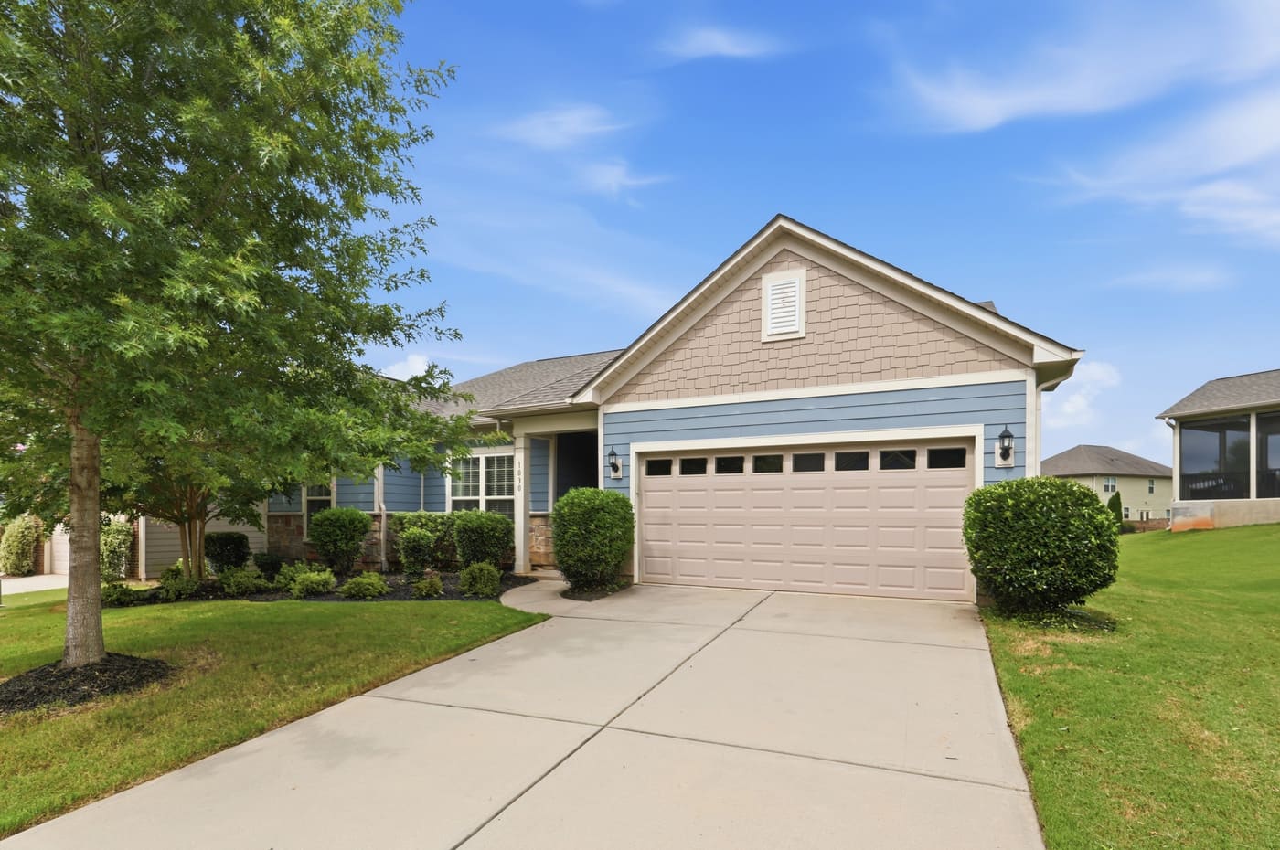 A straight-on daylight view of the front elevation, garage at center.