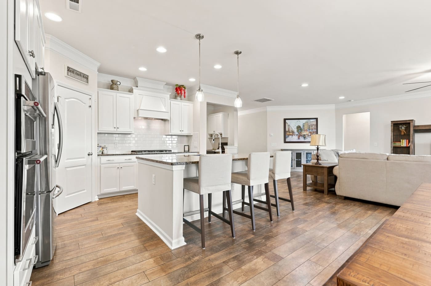 The kitchen with its granite island, wall oven and refrigerator.