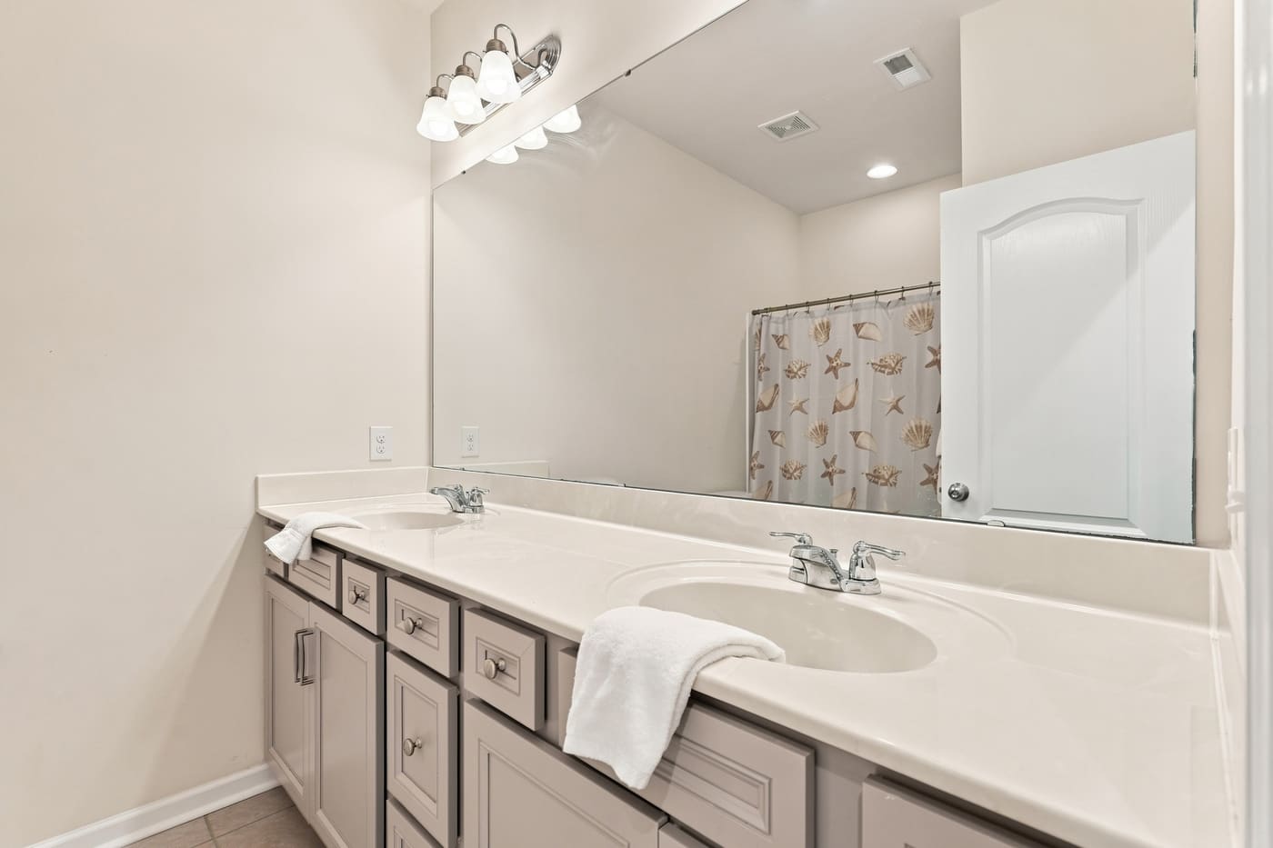 The secondary bath with a long vanity and a tub-shower.