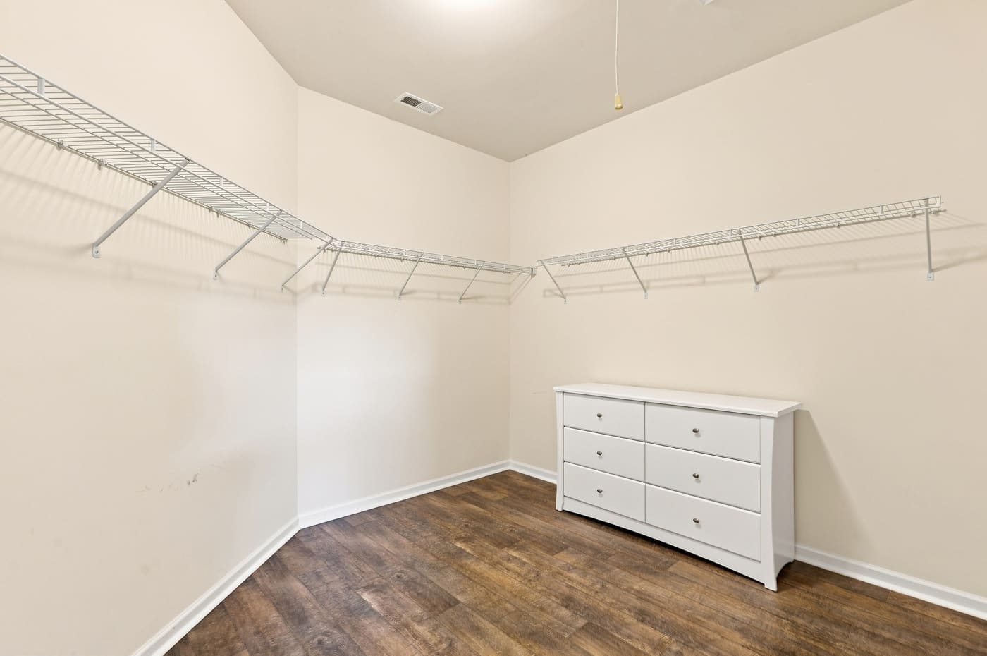 The primary walk-in closet, fitted out on three walls.